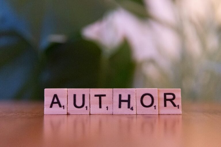 Scrabble tiles forming the word 'Author' on a wooden table, creativity concept.